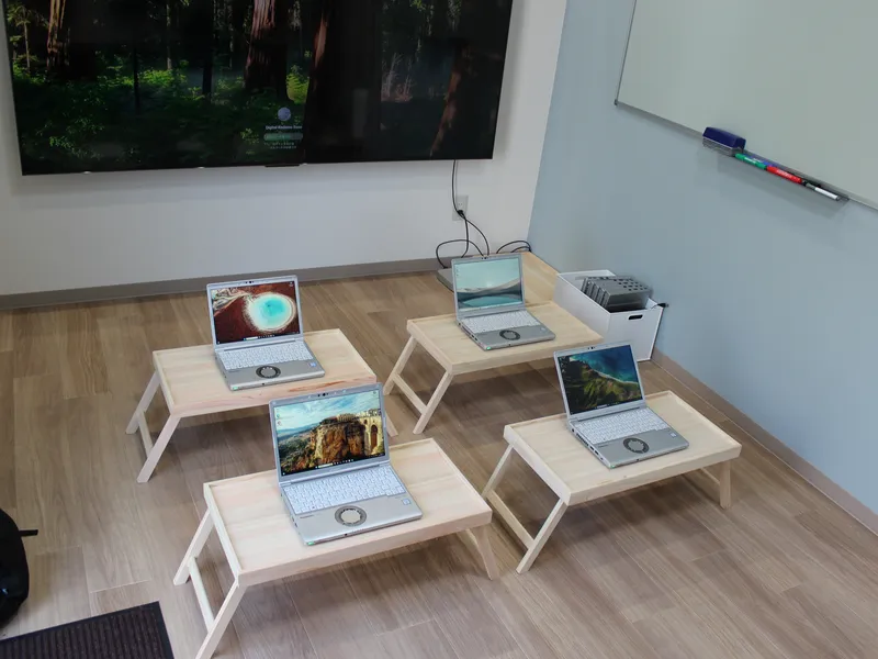 Laptops on low tables in a quiet room