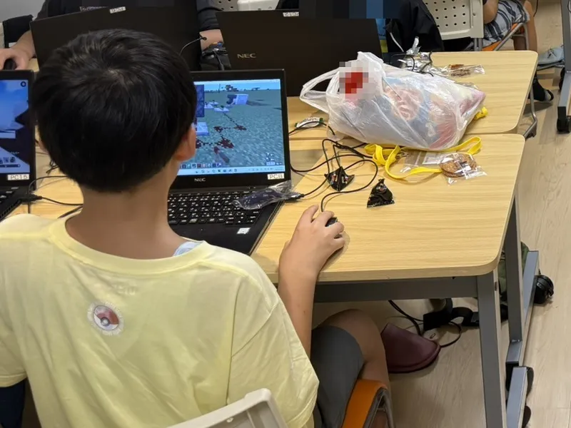 A child playing Minecraft on a laptop at the After-School Lab